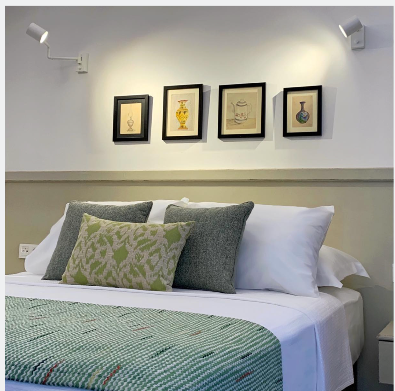 Sekiz Oda bed with green textiles and framed ceramic art